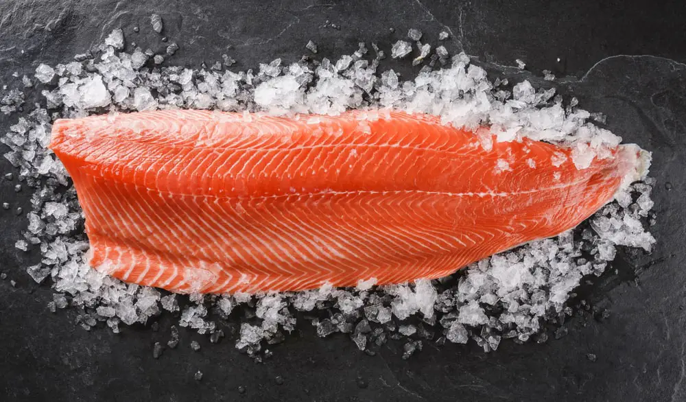 Fresh,Raw,Salmon,Fish,Steak,On,Ice,Over,Dark,Stone